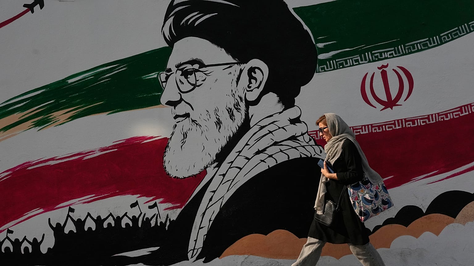 امرأة أمام جدارية لخامنئي في شارع آزادي بطهران، 29 يوليو 2026