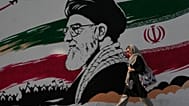 امرأة أمام جدارية لخامنئي في شارع آزادي بطهران، 29 يوليو 2026
