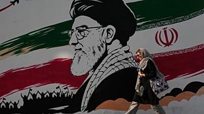 امرأة أمام جدارية لخامنئي في شارع آزادي بطهران، 29 يوليو 2026