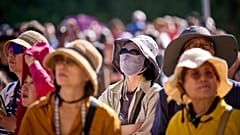 Unas mujeres asiáticas se tapan ante el sol mientras ven la Sagrada Familia en Barcelona