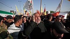 يحمل المشيعون توابيت ملفوفة بالعلم الإيراني على اليسار والعلم العراقي على اليمين خلال جنازة جماعية للمستشارين الإيرانيين ومقاتلي قوات التعبئة الشعبية الذين قتلوا في غارات جوية