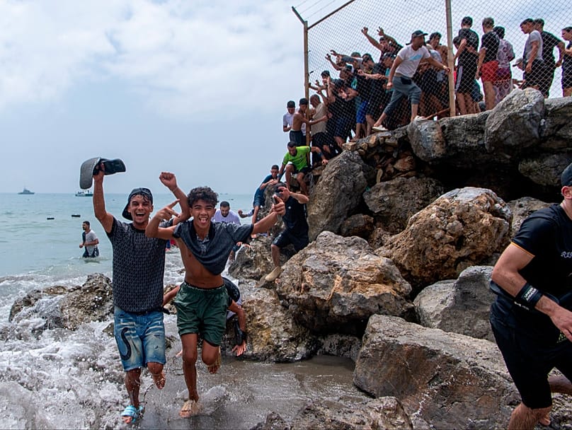 Migrantes cruzan desde Marruecos hacia el enclave español de Ceuta, el jueves 30 de julio de 2026. (Foto AP/Antonio Sempere)