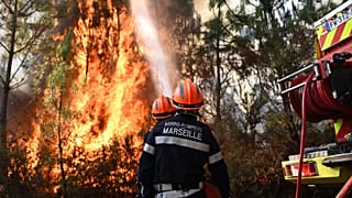 I vigili del fuoco lavorano per spegnere un incendio nella foresta vicino a Blagon, durante i roghi nel sud-ovest della Francia, mercoledì 29 luglio 2026.