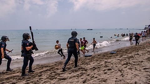 Agentes da polícia espanhola intervêm enquanto migrantes atravessam a fronteira de Marrocos para o enclave espanhol de Ceuta