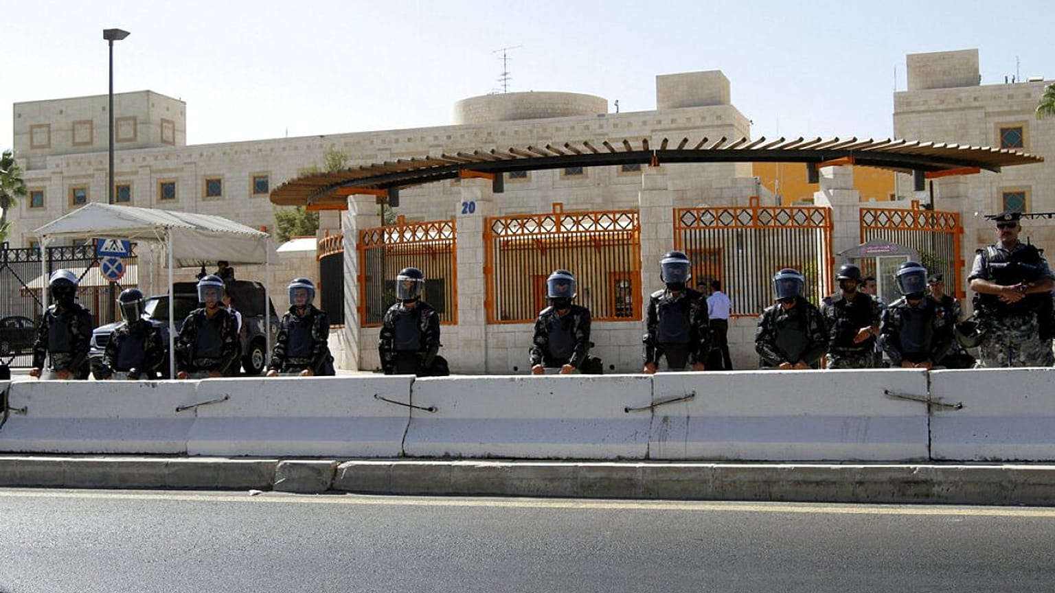 عناصر من شرطة مكافحة الشغب الأردنية يقفون للحراسة خلال احتجاج أمام السفارة الأمريكية في عمان، الأردن، يوم الجمعة 14 سبتمبر/أيلول 2012
