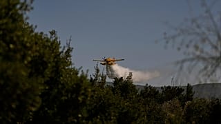 FILE: A water-bombing plane spreads water to extinguish a fire in a forested area in Guzelyeli, on the outskirts of Canakkale, 12 August 2025