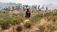 Eine marokkanische Sicherheitskraft sichert die Grenze, während Menschen versuchen, von der nordmarokkanischen Stadt Fnideq in die spanische Exklave Ceuta zu gelangen.