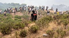 Eine marokkanische Sicherheitskraft sichert die Grenze, während Menschen versuchen, von der nordmarokkanischen Stadt Fnideq in die spanische Exklave Ceuta zu gelangen.