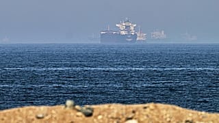 Navios de carga são vistos ao largo do estreito de Ormuz, a partir de uma costa rochosa perto de Khor Fakkan, Emirados Árabes Unidos, sexta‑feira, 1 de maio de 2026