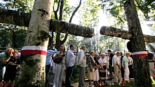 Emberek sétálnak a sírok között a Powazki katonai temetőben a varsói felkelés 65. évfordulóján, Varsóban, Lengyelországban, 2009. augusztus 1-jén
