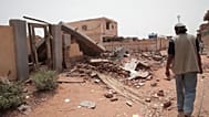 رجل يمر بجوار منزل تعرض للدهس خلال القتال الأخير في الخرطوم بالسودان، الثلاثاء 25 أبريل 2023.