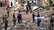 Spanish army soldiers and Guardia Civil officers stand guard as migrants return to Morocco from the Spanish enclave of Ceuta, Saturday, Aug. 1, 2026.
