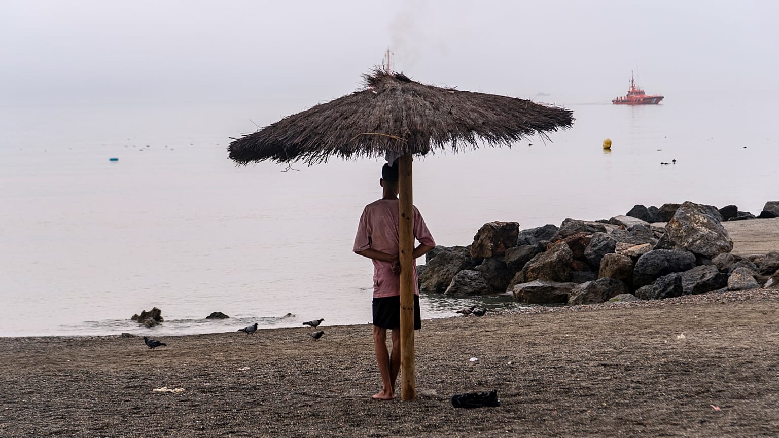 A man who crossed from Morocco stands on a beach in the Spanish enclave of Ceuta, Saturday, Aug. 1, 2026. 