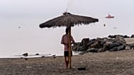 A man who crossed from Morocco stands on a beach in the Spanish enclave of Ceuta, Saturday, Aug. 1, 2026. 