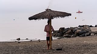 A man who crossed from Morocco stands on a beach in the Spanish enclave of Ceuta, Saturday, Aug. 1, 2026. 
