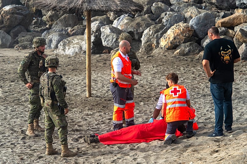Spanish army soldiers and Red Cross workers assist a migrant who swam from Morocco to the Spanish enclave of Ceuta, Saturday, Aug. 1, 2026.