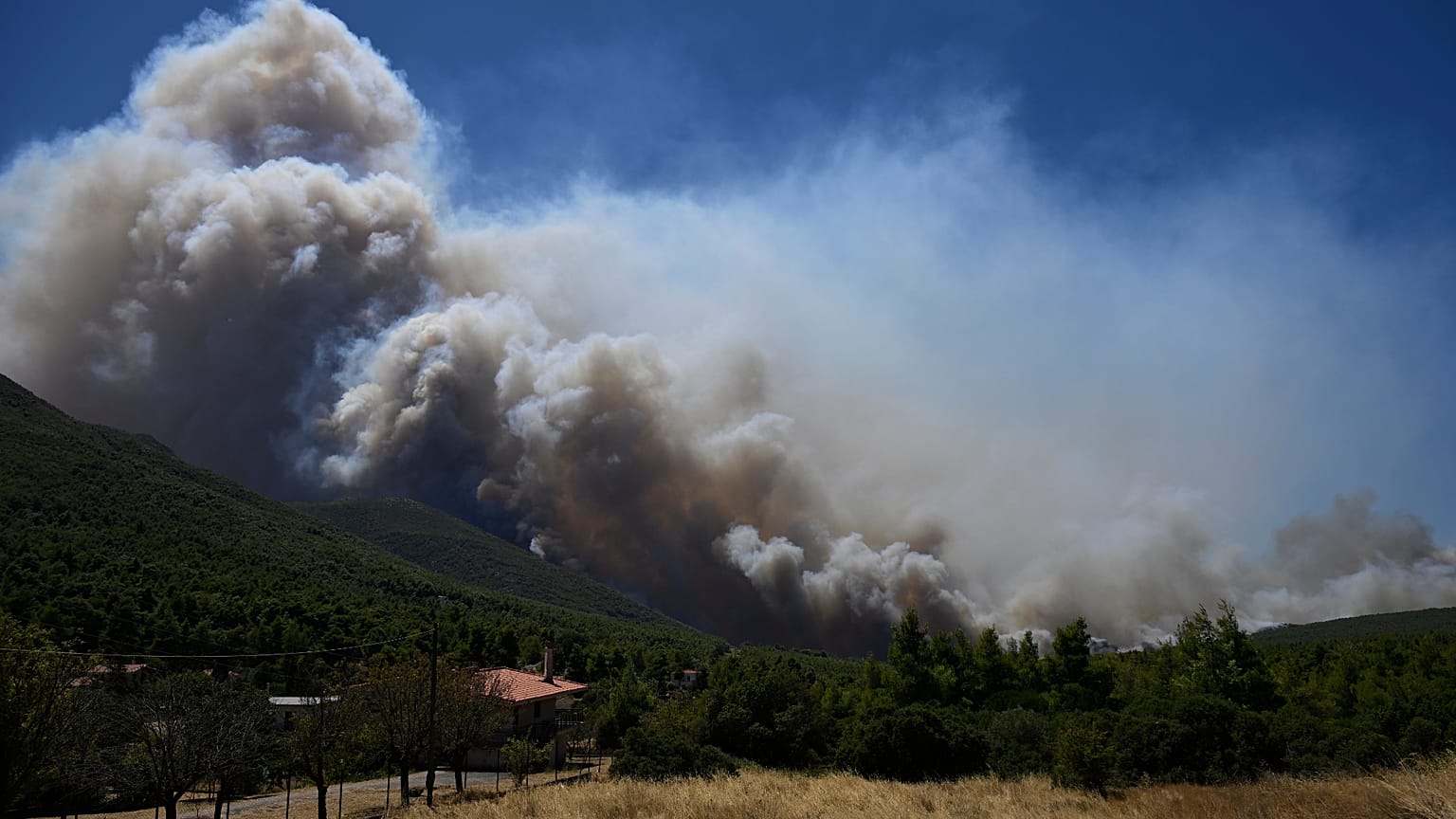 Smoke billows from a wildfire approaching Krio Pigadi near Porto Germeno, northwest of Athens, Greece, Saturday, Aug. 1, 2026.