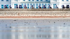 Pessoas desfrutam do tempo primaveril soalheiro em cadeiras de praia na ilha norte-alemã de Norderney, Alemanha, em 29 de março de 2019.