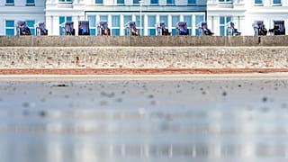 Menschen genießen das sonnige Frühlingswetter in Strandkörben auf der norddeutschen Insel Norderney, Deutschland, am 29. März 2019.