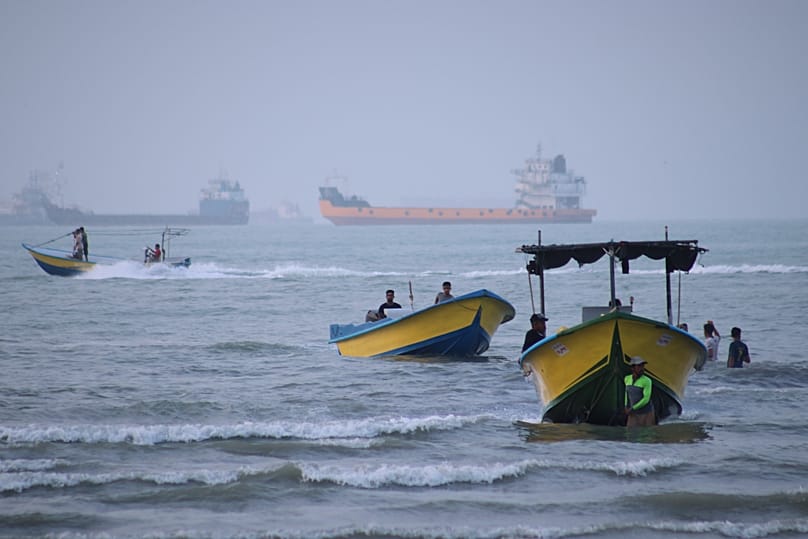Small boats line the shore as cargo ships and other commercial vessels appear anchored in the Strait of Hormuz off Bandar Abbas, Iran, Monday, July 27, 2026.