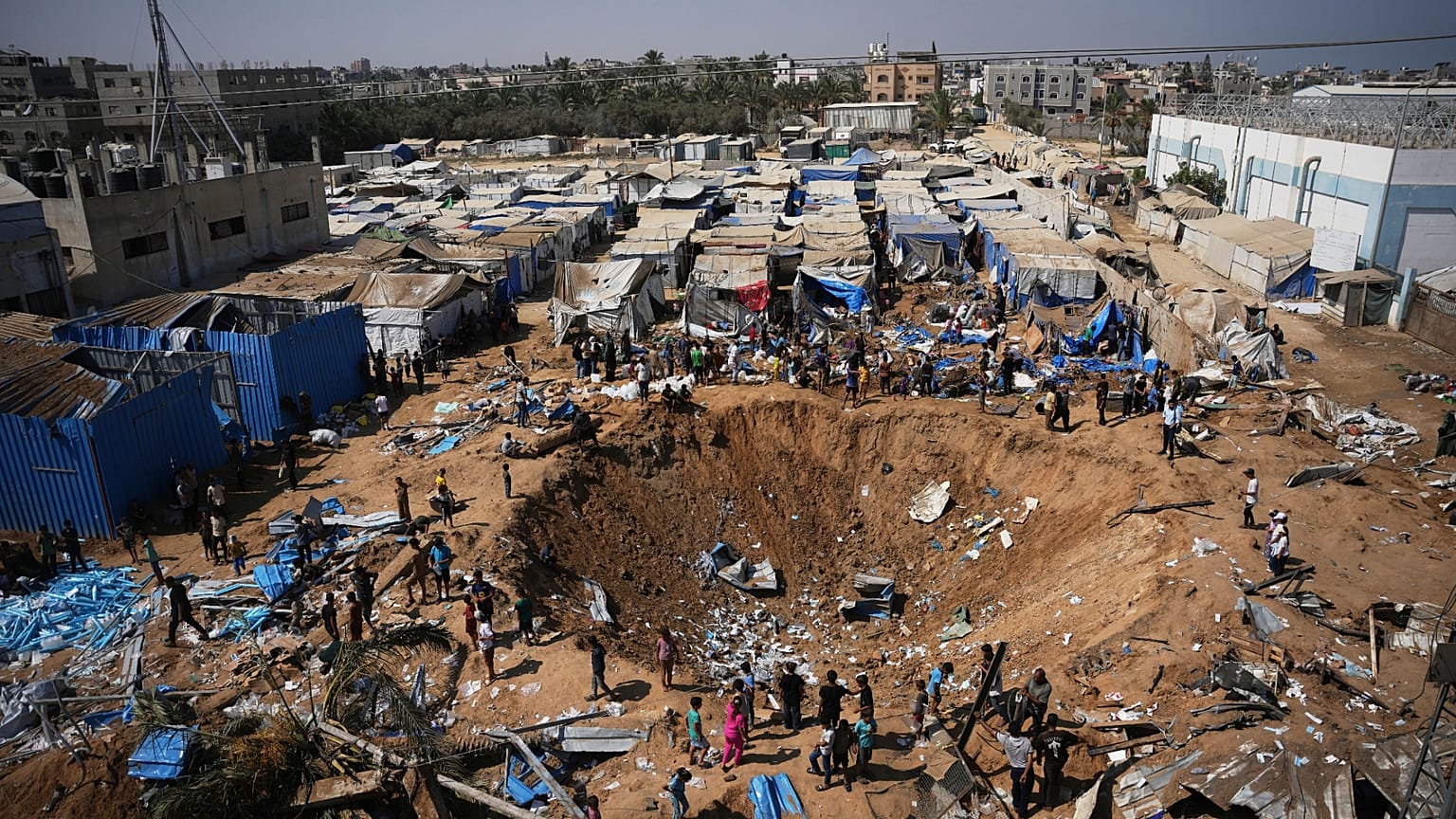 فلسطينيون يتفقدون موقع غارة جوية إسرائيلية قرب مستشفى الأقصى في دير البلح بوسط قطاع غزة، السبت 1 أغسطس/آب 2026. (AP Photo/عبد الكريم حنا)