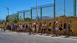 Migrants who crossed into Ceuta are escorted by Spanish soldiers toward the Spanish-Moroccan border for their return to Morocco from the Spanish enclave, Sunday, Aug.2,2026