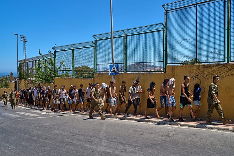 Migrants who crossed into Spain are escorted by Spanish soldiers toward the Spanish-Moroccan border for their return to Morocco, 2 August, 2026