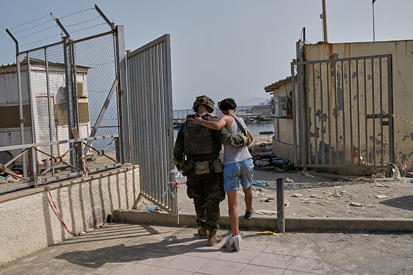 İspanya'ya geçen yaralı bir göçmen, Ceuta kenti sınırında bir İspanyol askerinin yardımıyla Fas'a geri dönüyor, 1 Ağustos 2026.