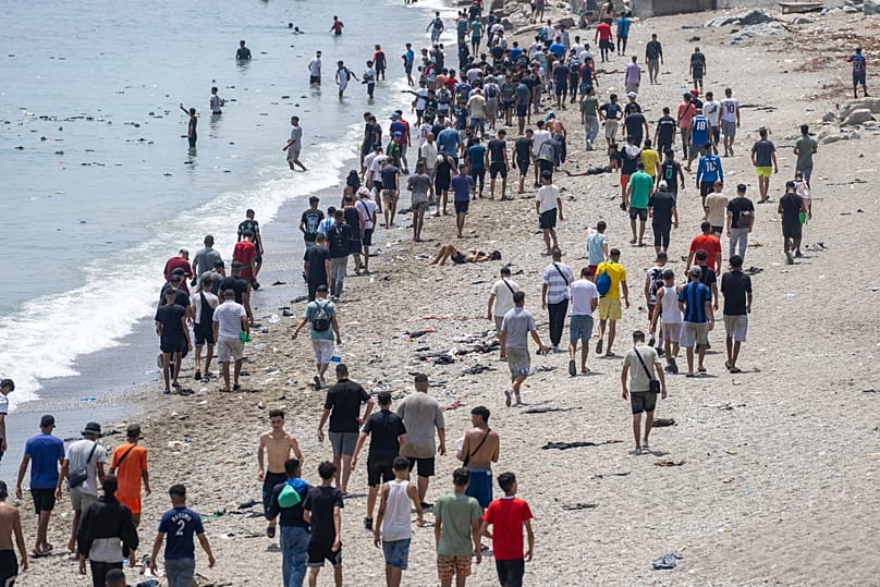 İnsanlar, Fas'ın kuzeyindeki Fnideq kentinden İspanya'nın Ceuta toprağına geçme girişiminde bulunduktan sonra plajda yürüyor, 31 Temmuz 2026.