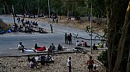 Migrants who crossed into Spain from Morocco sit outside the temporary immigrant stay center (CETI) in the Spanish enclave of Ceuta, Sunday, Aug. 2, 2026.