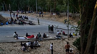Migrants who crossed into Spain from Morocco sit outside the temporary immigrant stay center (CETI) in the Spanish enclave of Ceuta, Sunday, Aug. 2, 2026.