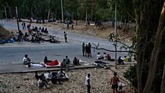 Migrantes que chegaram a Espanha vindo de Marrocos permanecem sentados em frente ao Centro de Estadia Temporária de Imigrantes (CETI) em Ceuta