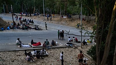 Μετανάστες που πέρασαν στην Ισπανία από το Μαρόκο παραμένουν καθιστοί μπροστά στο κέντρο προσωρινής φιλοξενίας μεταναστών (CETI) στον ισπανικό θύλακα της Θέουτα