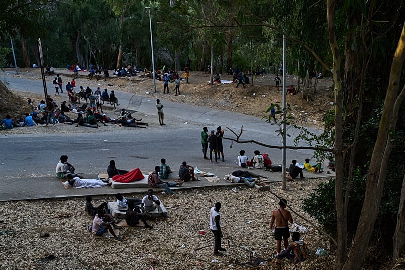 Migrants who crossed into Spain from Morocco sit outside the temporary immigrant centre in the Spanish enclave of Ceuta, 2 August, 2026