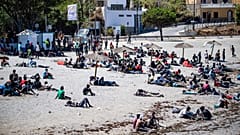 Migrants who crossed into Spain from Morocco gather on a beach in the Spanish enclave of Ceuta, 2 August, 2026