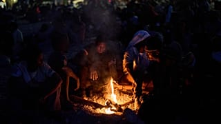 Migrants who crossed into Spain from Morocco gather around a bonfire on a beach in the Spanish enclave of Ceuta, 2 August, 2026