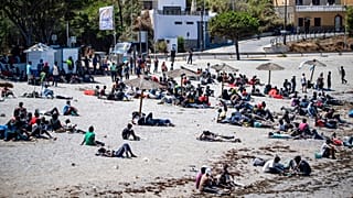 Migrants who crossed into Spain from Morocco gather on a beach in the Spanish enclave of Ceuta, 2 August, 2026