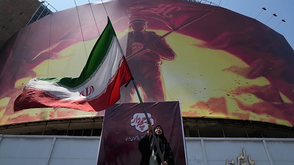 امرأة تلوّح بالعلم الإيراني، وسط طهران، إيران، السبت 1 آب/أغسطس 2026.