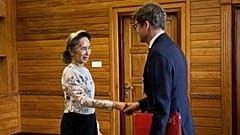 A líder deposta de Myanmar, Aung San Suu Kyi, cumprimenta com um aperto de mão Arnaud de Baecque, da Cruz Vermelha, em Naypyidaw, 3 de agosto de 2026