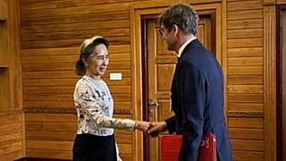 Myanmar's ousted leader Aung San Suu Kyi shakes hands with Arnaud de Baecque from the Red Cross in Naypyidaw, 3 August, 2026