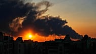 صورة تعبيرية- تغرب الشمس خلف عمود من الدخان يتصاعد جراء ضربة عسكرية أمريكية-إسرائيلية في طهران