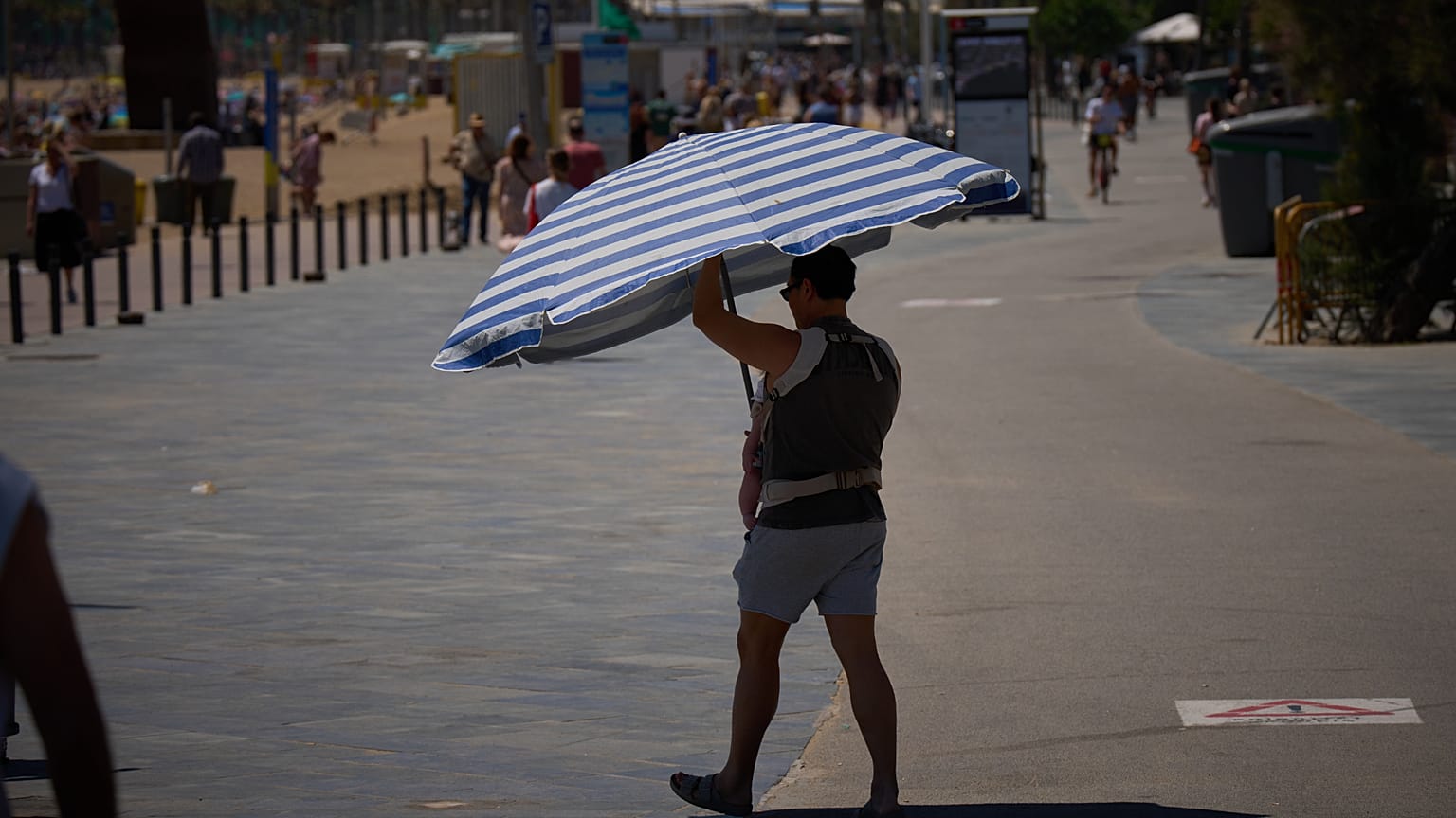 Un homme tient un parapluie en marchant près d'une plage de Barcelone, en Espagne, mercredi 27 mai 2026.