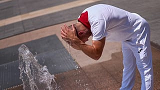 Un asistente a las fiestas se refresca en una fuente mientras las temperaturas se disparan durante las celebraciones de San Fermín en Pamplona, ​​España, el 7 de julio de 2026