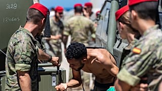 Un migrante que cruzó a España desde Marruecos bebe agua distribuida por soldados españoles en el enclave español de Ceuta, el 2 de agosto de 2026.