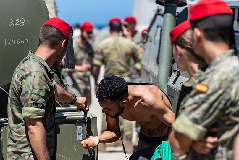 Un migrante que ha cruzado a España desde Marruecos bebe agua repartida por soldados españoles en el enclave español de Ceuta, el domingo 2 de agosto de 2026. 