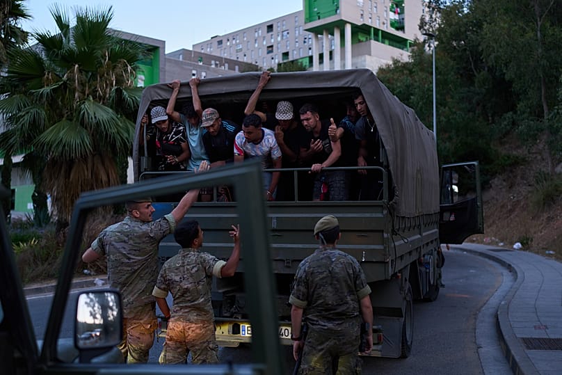 Inmigrantes que cruzaron a España son escoltados por soldados españoles hacia la frontera hispano-marroquí para su retorno a Marruecos el 2 de agosto de 2026.