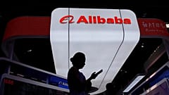ARQUIVO - Um visitante passa em frente ao stand da Alibaba durante a 3.ª Exposição Internacional da Cadeia de Abastecimento da China, em Pequim, China, 18 de julho de 2025.