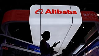 FILE - A visitor walks in front of Alibaba booth during the 3rd China International Supply Chain Expo in Beijing, China. July 18, 2025.