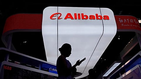 FILE - A visitor walks in front of Alibaba booth during the 3rd China International Supply Chain Expo in Beijing, China. July 18, 2025.