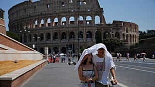 Caldo record in Italia, due turisti si riparano dal sole